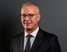 Thomas Treß – Geschäftsführer  – in dunklem Anzug mit dunkler Krawatte schaut direkt in die Kamera (Foto)