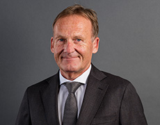 Hans-Joachim Watzke – Vorsitzender der Geschäftsführung – in dunklem Anzug mit dunkler Krawatte schaut direkt in die Kamera (Foto)