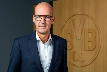 Carsten Cramer – Sprecher der Geschäftsführung – in dunklem Anzug mit dunkler Krawatte schaut direkt in die Kamera (Foto)