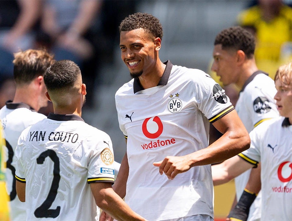 Mehrere Dortmund Spieler stehen beisammen, Nmecha ist in der Mitte und lächelt (Foto)