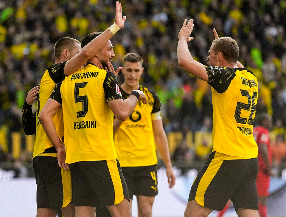 Mehrere BVB Spieler, rund um Bensebaini und Ryerson jubeln und klatschen ab (Foto)